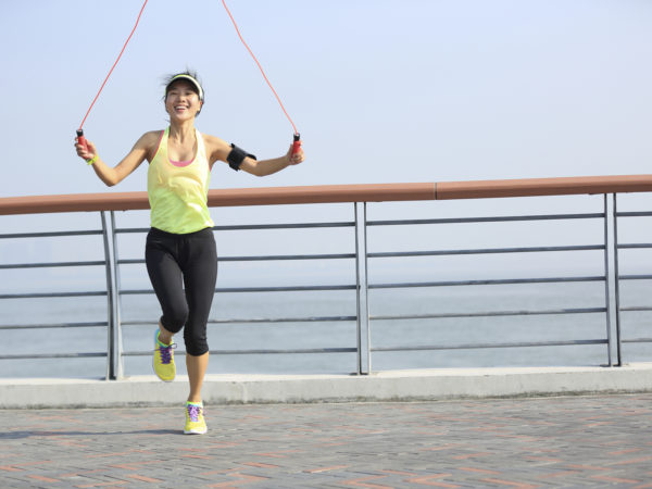 young fitness woman jumping rope at seaside